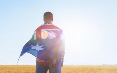 Uomo con una bandiera dell'Australia in piedi nel campo del mattino